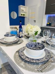 a table with plates and bowls and glasses on it at Apartamenty pod wieżą 2 in Olsztynek