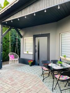 a patio with a table and chairs and a swing at Apartamenty pod wieżą 2 in Olsztynek