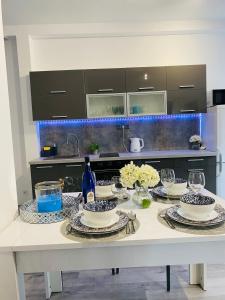 a kitchen with a table with plates and wine glasses at Apartamenty pod wieżą 2 in Olsztynek +23 photos
