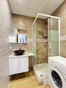 a bathroom with a sink and a washing machine at Résidence Harmony in Vichy