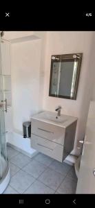 a bathroom with a sink and a mirror and a toilet at studio a 800m de la plage , parking privé in Sète