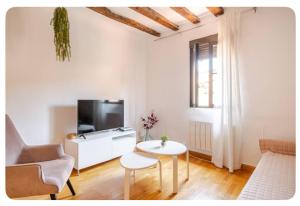 salon z kanapą, telewizorem i stołem w obiekcie El Apartamento en Ópera Palacio Real w Madrycie