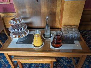 a table with glasses and a bottle and cupcakes at Maitlandfield House Hotel in Haddington