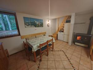 a kitchen and dining room with a table and a stove at KOČA PLANIKA, SVIŠČAKI in Ilirska Bistrica