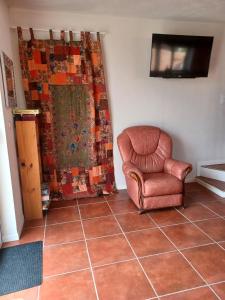 a living room with a chair and a television at La Biste in Mirepoix