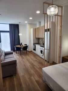 a room with a bed and a table and a kitchen at Dormavalencia Crónica in Valencia