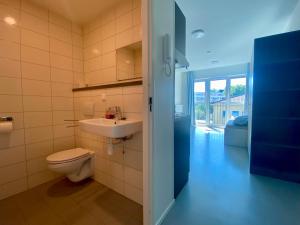 a bathroom with a toilet and a sink at Apartments Skyreach in Essen +79 photos