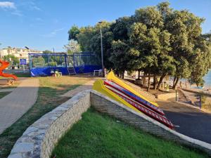 una panchina in un parco con parco giochi di Villa La Playa a Pola (Pula)