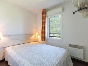a bedroom with a bed and a window at T2 cabine avec balcon, piscine et parking à Luz-Saint-Sauveur, proche commodités et stations de ski - FR-1-402-140 in Luz-Saint-Sauveur +7 photos
