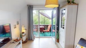 a living room with a sliding glass door to a patio at Ort Lemkenhafen "Westwind" in Westfehmarn