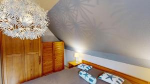 a bedroom with a chandelier and a bed at Ort Lemkenhafen "Westwind" in Westfehmarn