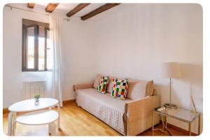 salon z kanapą i stołem w obiekcie El Apartamento en Ópera Palacio Real w Madrycie