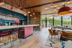 a restaurant with a bar with tables and chairs at Sunstar Pontresina in Pontresina