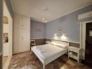 a bedroom with a white bed and white cabinets at Billy's House in Vasiliki