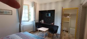 a bedroom with a desk and a bed and a chair at SALAMANDRE in Jouarre