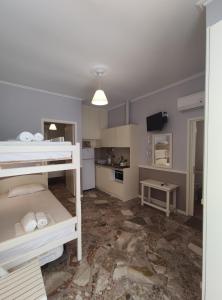 a bedroom with a bunk bed and a kitchen at Billy's House in Vasiliki