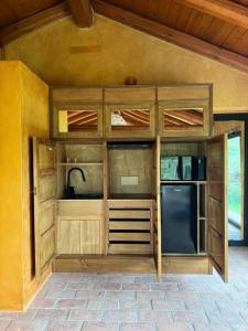 a kitchen with wooden cabinets and a black refrigerator at Glass Apartment Tenuta il Galletto in Casale Monferrato +14 photos