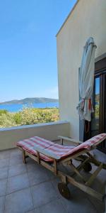 a bed with an umbrella next to a building at Villa Nikos in Agios Dimitrios
