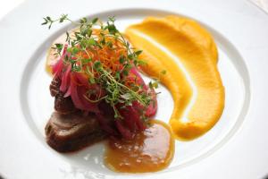 a plate of food with meat and vegetables and orange slices at Jotunheimen Fjellstue in Boverdalen +34 photos