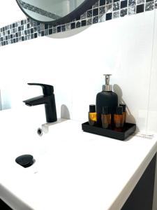 a bathroom sink with a soap dispenser on it at Wolu suites in Brussels