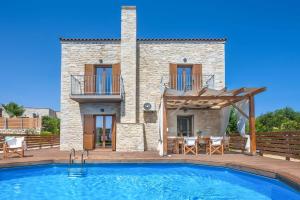 una villa con piscina frente a una casa en Villa Ouraria Klio, en Kiriánna 25 fotos más