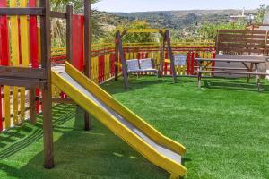 un parque infantil con un tobogán en el césped en Villa Ouraria Klio, en Kiriánna
