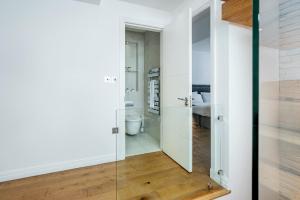 una porta a vetri che conduce a un bagno con servizi igienici di Welcome London - The Piazza a Londra Altre 127 foto