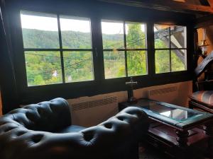 a living room with a leather couch and a glass table at Rustic Charm a Unique and Antique Apartment in Zagreb +6 photos