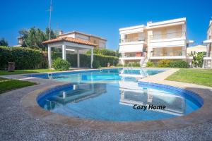 a swimming pool in front of a building at Cozy Home in Kriopigi
