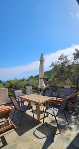 a wooden table and chairs with an umbrella at Villa Dimitra in Agios Dimitrios