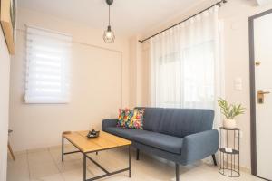 a living room with a blue couch and a table at Cozy Home in Kriopigi