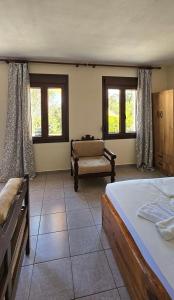 a bedroom with two beds and a couch and windows at Villa Dimitra in Agios Dimitrios
