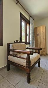 a wooden bench in a room with a window at Villa Dimitra in Agios Dimitrios