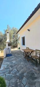 a patio with a picnic table and a stove at Villa Dimitra in Agios Dimitrios