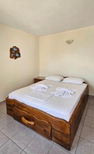 a bedroom with a large wooden bed with white sheets at Villa Dimitra in Agios Dimitrios