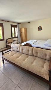 a bedroom with a large bed and a couch in it at Villa Dimitra in Agios Dimitrios