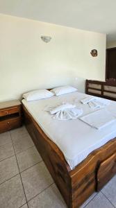 a wooden bed with white sheets and pillows on it at Villa Dimitra in Agios Dimitrios