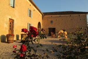 een binnenplaats van een gebouw met bloemen op de voorgrond bij Gîte - La Couderquié in Lautrec