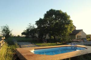 a swimming pool on top of a wooden deck at Gîte - La Couderquié in Lautrec