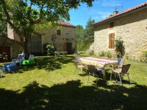 a table and chairs in the yard of a house at Maison charmante à Les Junies avec vue sur jardin in Les Junies