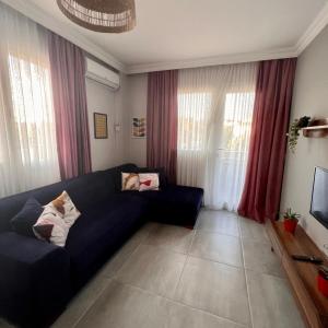 a living room with a blue couch and a tv at BiSuite Urla in Kuscular