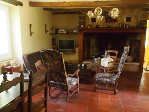 a living room with two chairs and a table at Maison charmante à Les Junies avec vue sur jardin in Les Junies