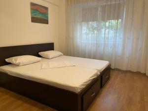 a bed in a bedroom with a large window at Apartament Techirghiol in Techirghiol