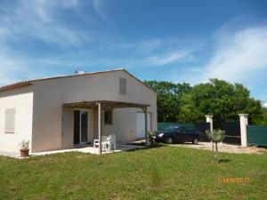 a small white house with a car parked in front at Villa THELISE in Le Muy