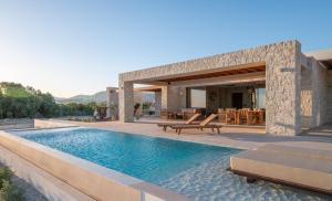 a villa with a swimming pool and a patio at POEMO VILLAS in Ierapetra