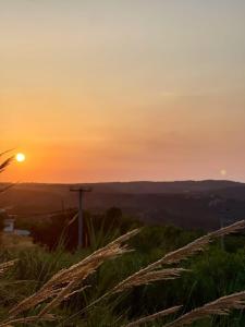 a sunset on a hill with tall grass at Trachos Traditional House in Sálakos +36 photos