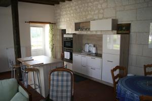 a kitchen with white cabinets and a counter top at Grand gite en rez-de-jardin in Saint-Aignan