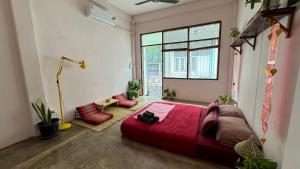 a bedroom with a large red bed and red chairs at Baan YentaFo - Pink House 3rd floor in Chinatown