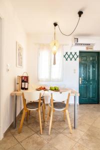 a kitchen with a table and chairs in a room at SounioKallisti Suites 3 in Análipsis