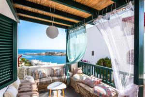 a balcony with a couch and a view of the ocean at SounioKallisti Suites 3 in Análipsis
